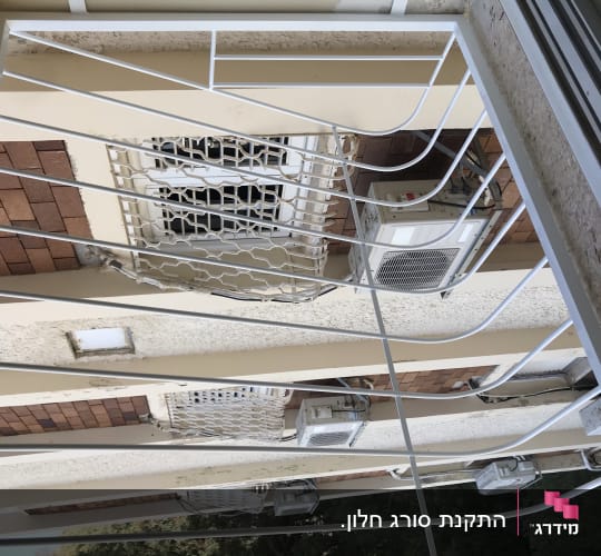 סורגי מתכת לבנים על חלון בניין